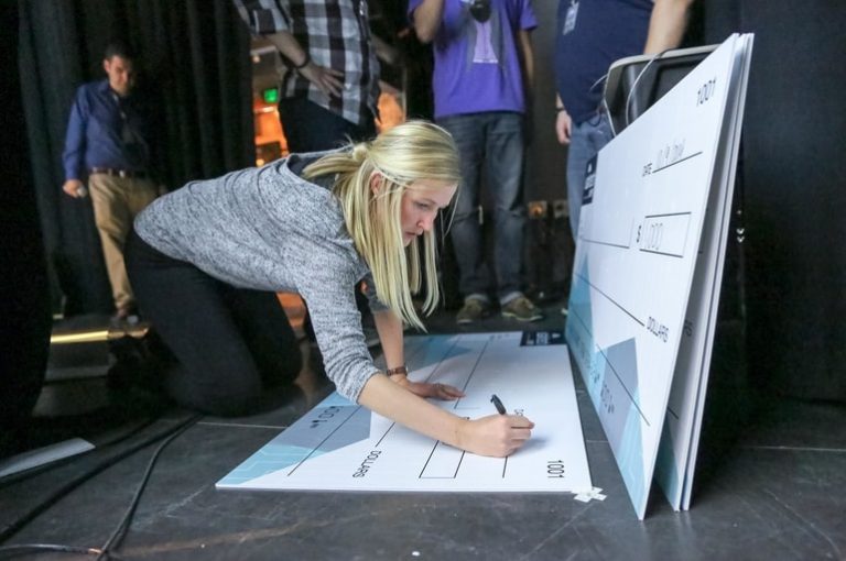 Woman write check to winner at the Utah Tech week