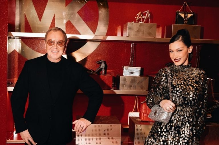 Michael Kors founder in a pose with model