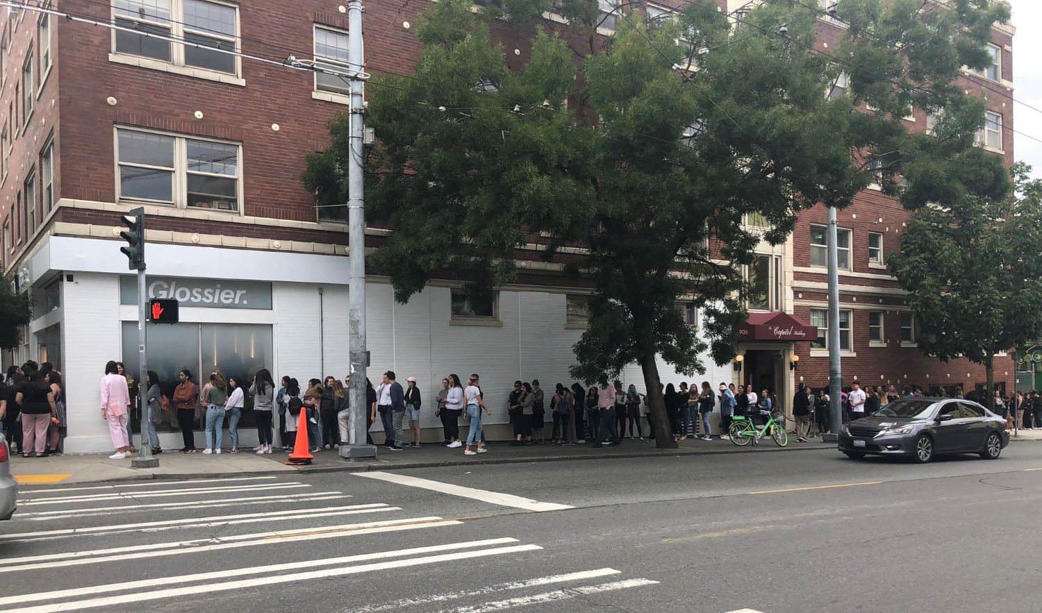 Glossier store with full of people line up
