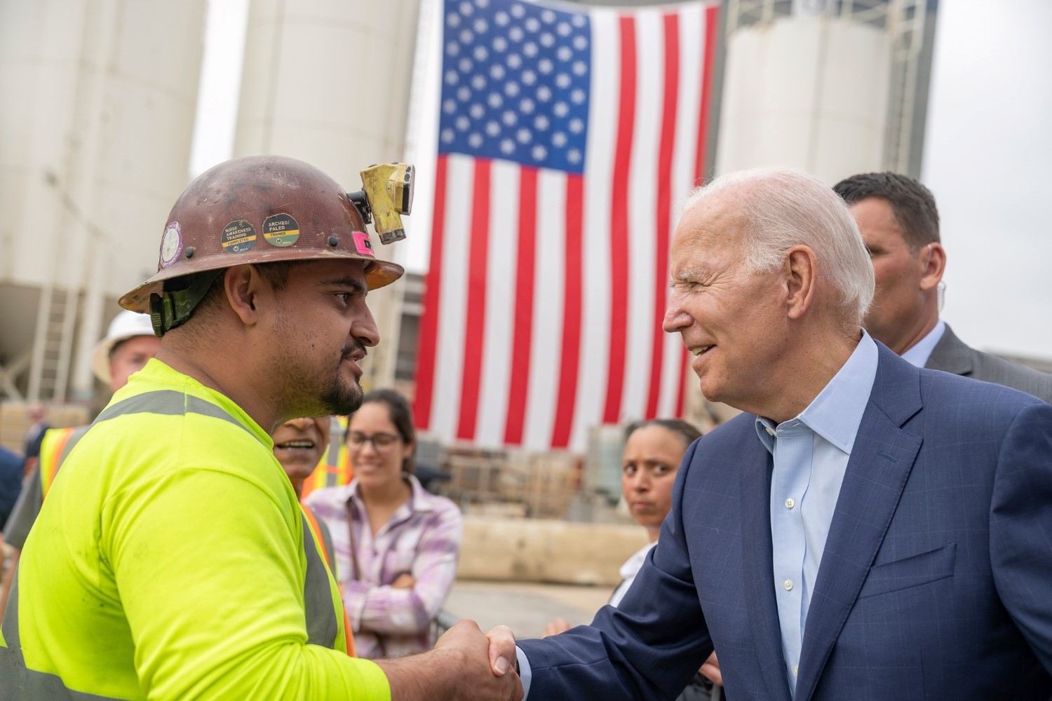 Biden holding hands with a construction staff