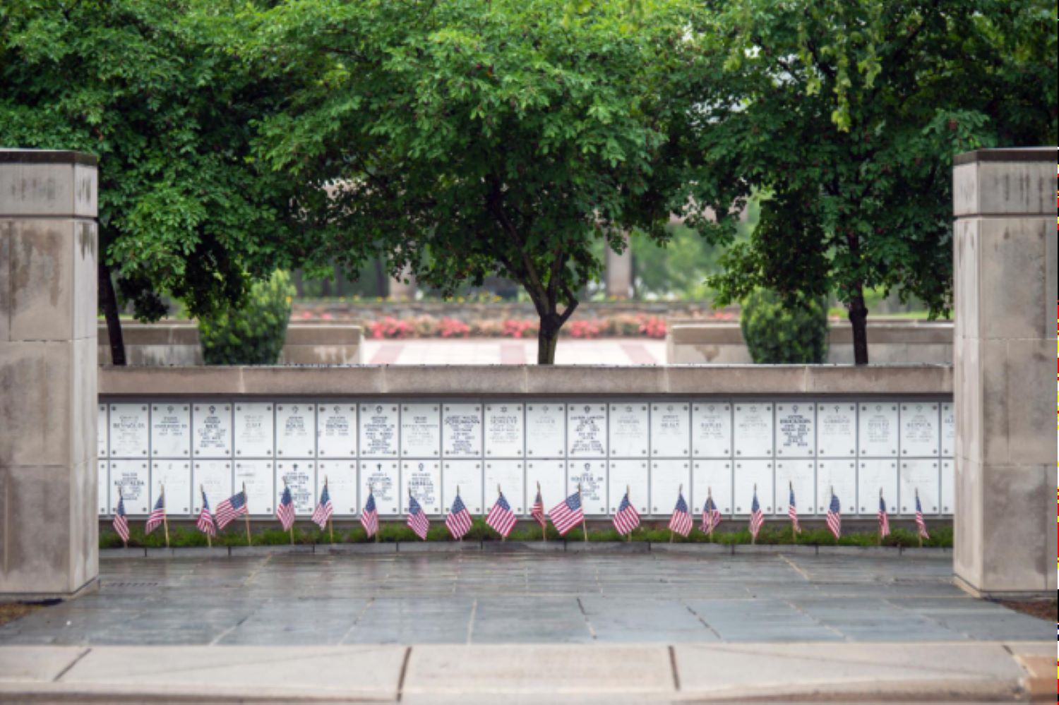 Flags flags stand neatly at the base of the columbarium walls in Arlington National Cemetery